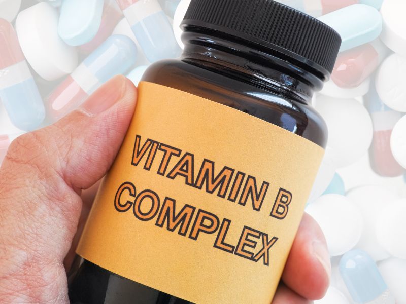 Bočica sa natpisom „Vitamin B Complex“ u ruci – suplement vitamina B kao što je Beviplex za energiju i nervni sistem.
