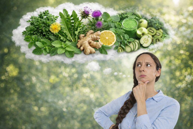 Žena zamišljeno gleda u stranu, iznad nje su u oblačiću prikazani zdravi sastojci poput limuna, đumbira, zelenog povrća i voća