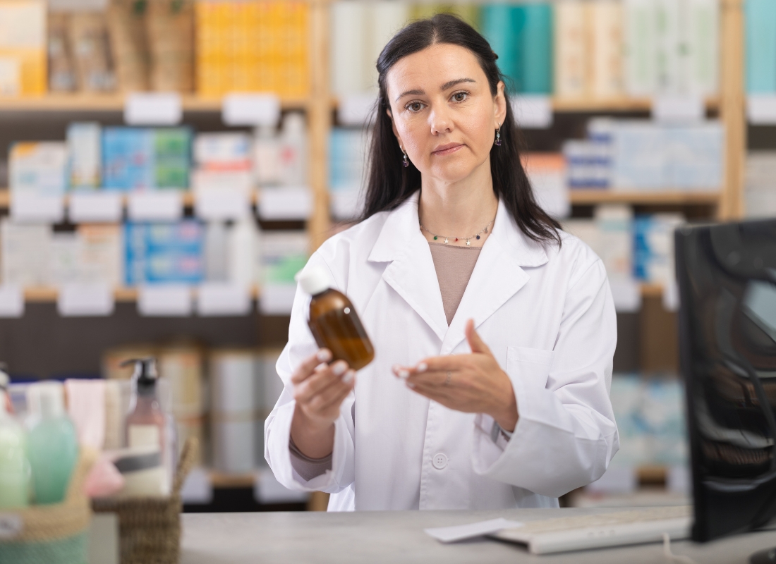 farmaceutkinja u apoteci drži sirup za produktivan kašalj u ruci