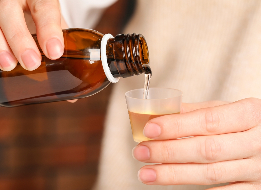 ženska osoba sipa sirup u čep